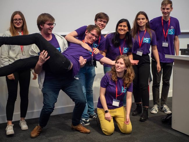 A group of 8 people wearing purple t-shirts